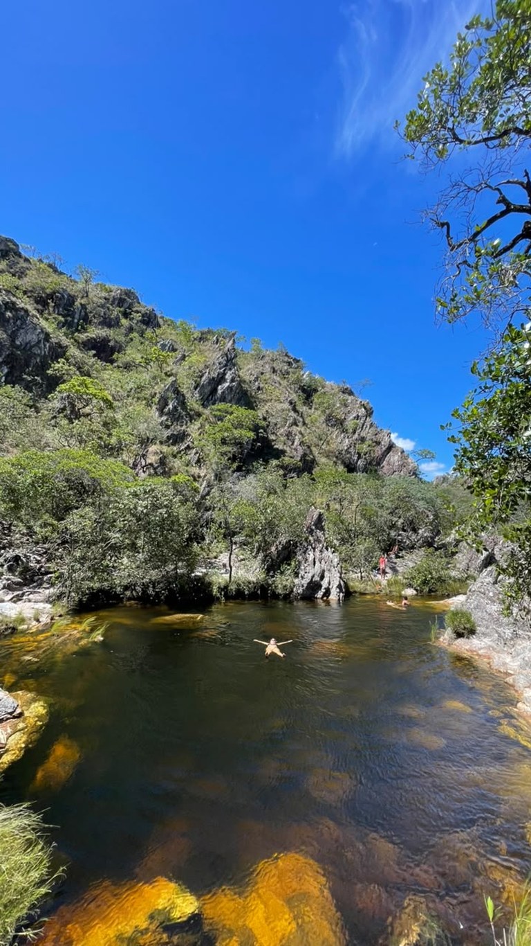 Turista boiando no Poço Xamânico cercado de rochas na Reserva Renascer, Cavalcante