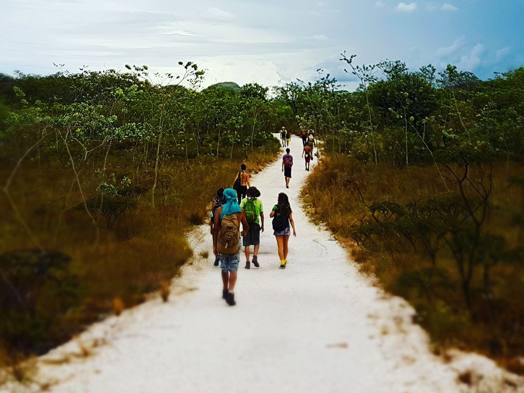 Pessoas fazendo passeio no parque nacional da Chapada dos Veadeiros caminhando pelo cerrado com guia local