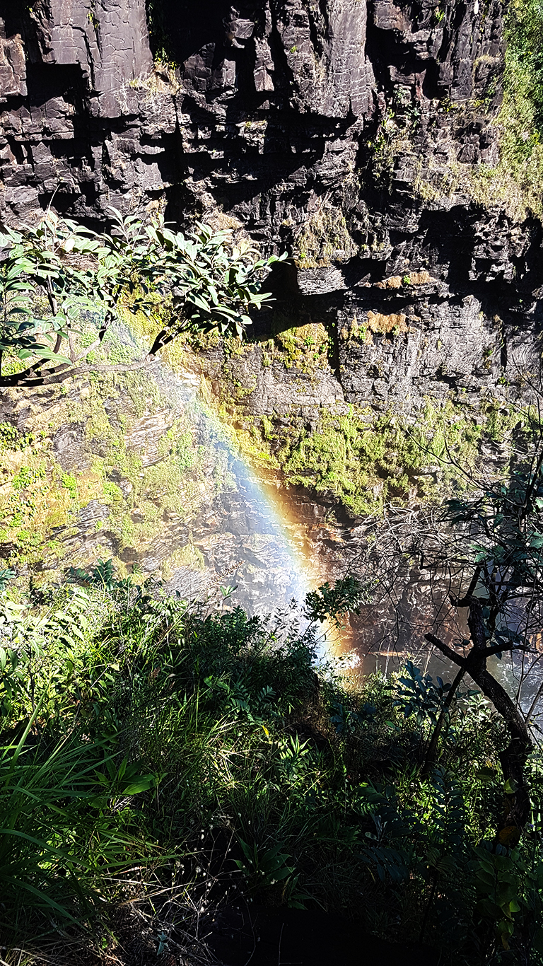 Arco-íris formado no último penhasco da trilha pela parte da manhã em dia de muito sol nas cataratas dos Couros na Chapada dos Veadeiros